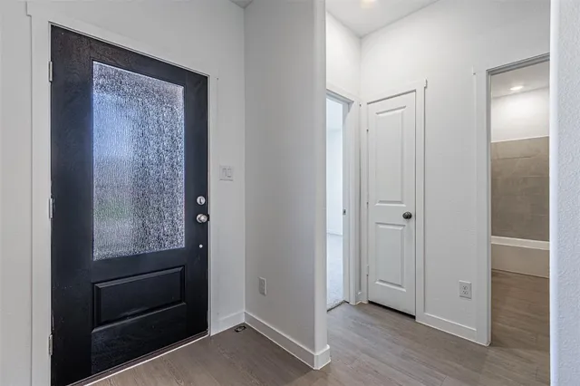 a view of hallway with closet and wooden floor