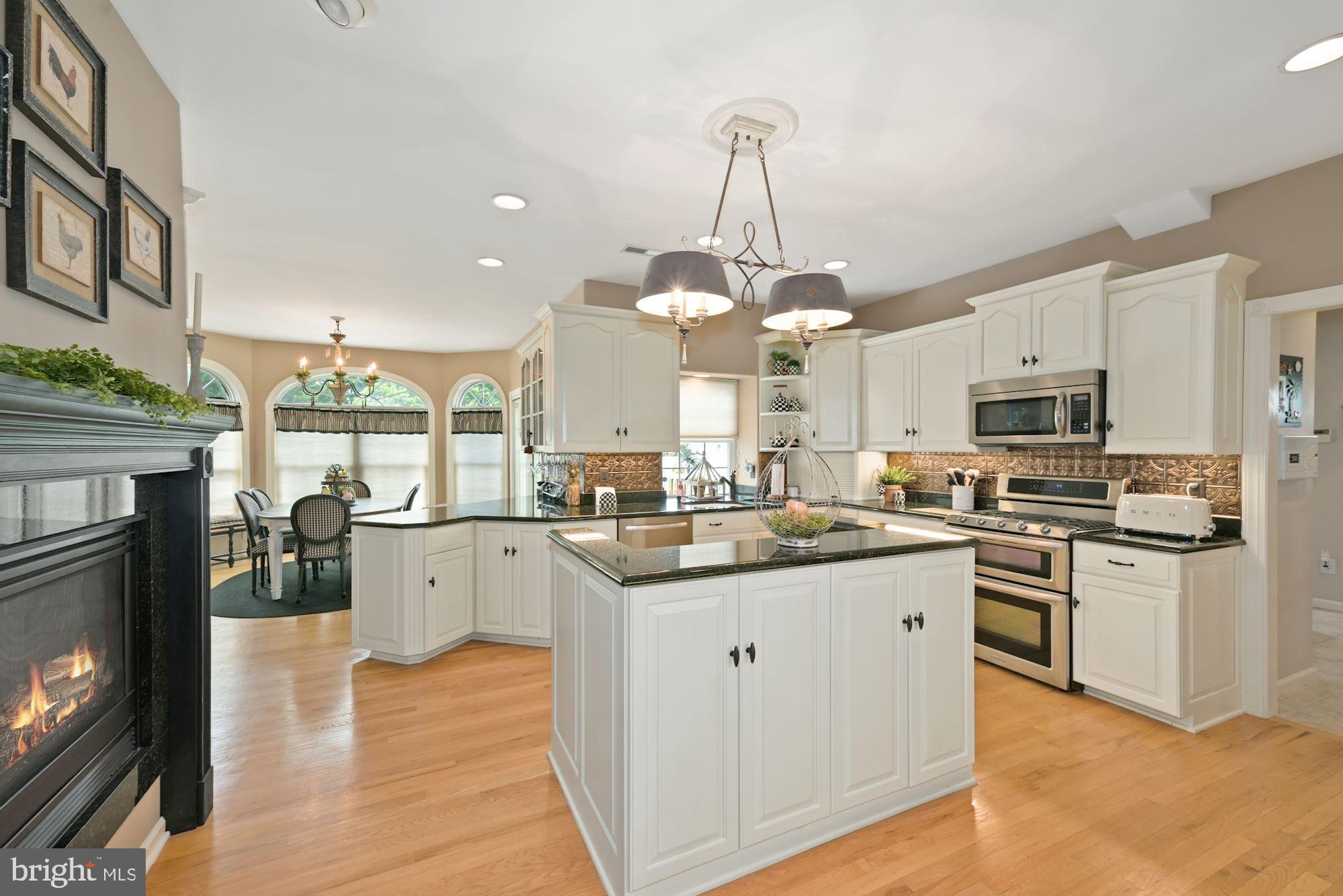 360 Chapel Heights Road Sewell, NJ 08080 - Photo 19 of 58 a kitchen with stainless steel appliances granite countertop a stove top oven a sink dishwasher and a fireplace with wooden floor