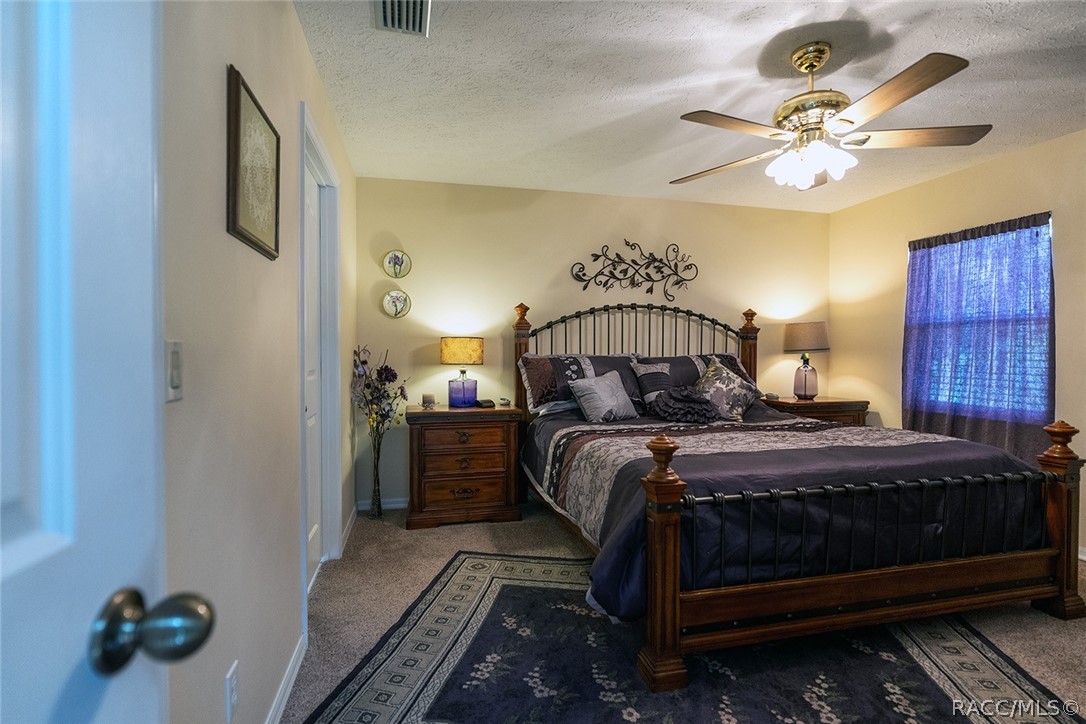 800 Balmoral Court Inverness, FL 34453 - Photo 22 of 72 a bedroom with a bed and a chandelier