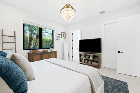 a view of a patio with couches and a table and chairs with wooden floor and fence