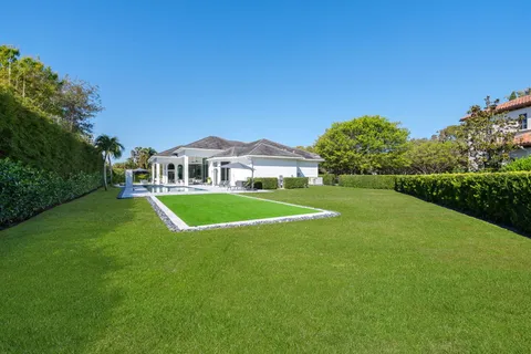 a view of a white house with a yard and large tree