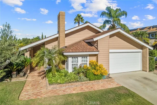 a front view of a house with a yard and potted plants