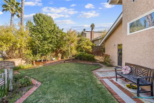 a view of a house with a yard and potted plants