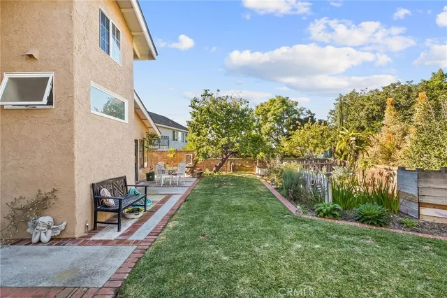 a view of a house with a yard and potted plants