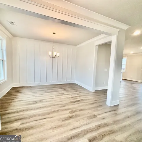 a view of a livingroom with wooden floor and staircase