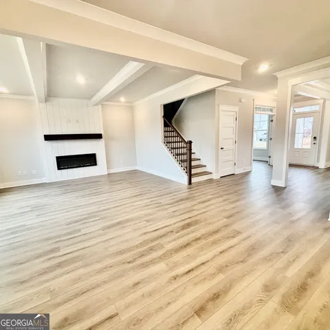 a view of empty room with wooden floor and fireplace
