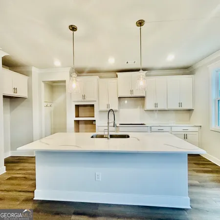 a kitchen that has a sink a stove and cabinets