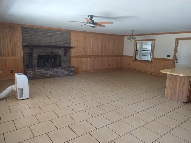 an empty room with windows and fireplace