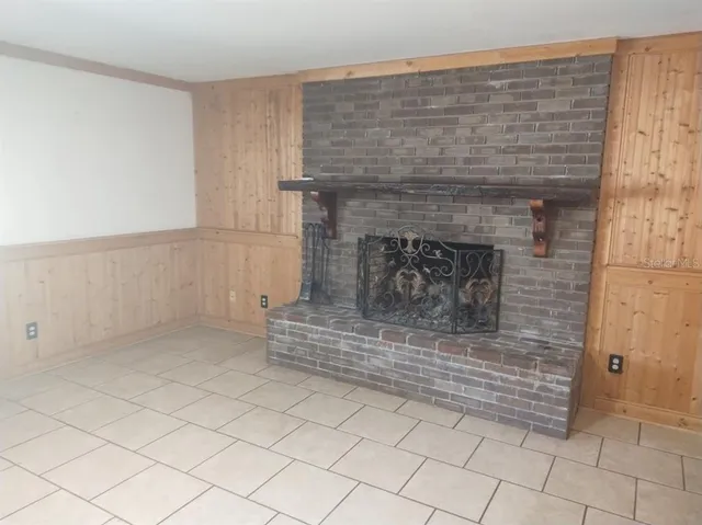 an empty room with chandelier fan