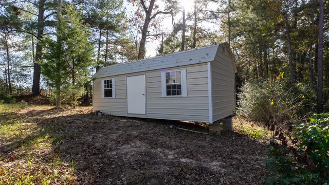 a view of an empty room with a kitchen and wooden floor