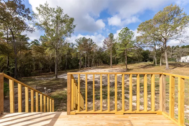 a view of a house with backyard and trees