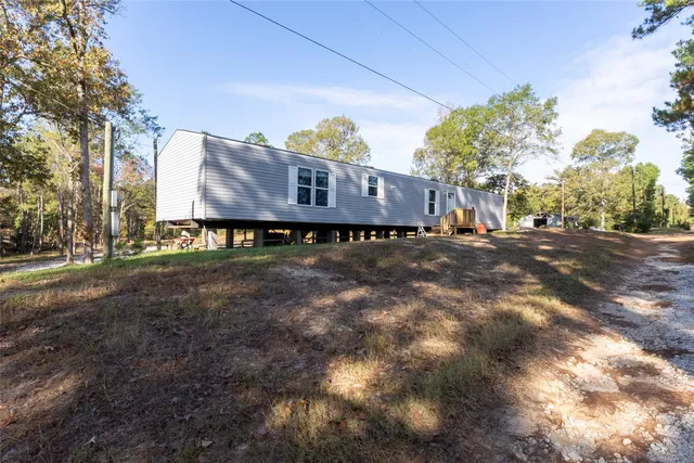 a view of a house with a yard and large tree