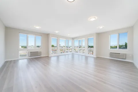 a view of a kitchen with kitchen island a sink wooden floor and a refrigerator