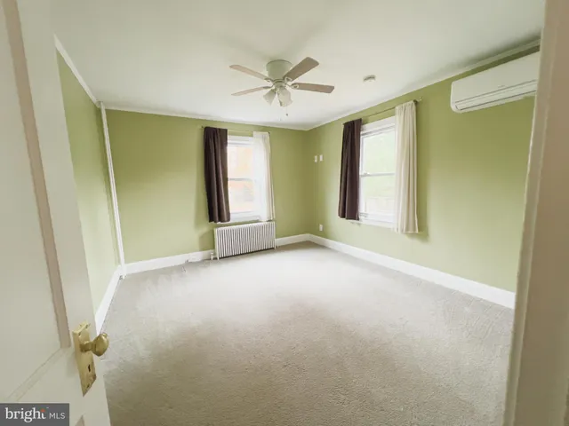 a view of a livingroom with a ceiling fan and windows