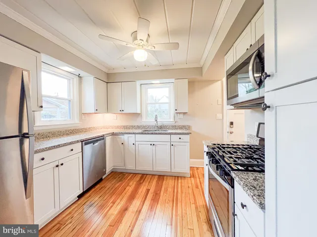 a kitchen with stainless steel appliances a sink a stove a refrigerator and cabinets