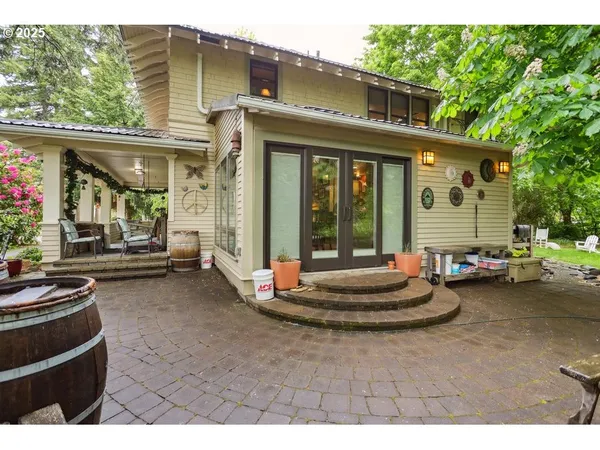 a view of a house with a barbeque and potted plants