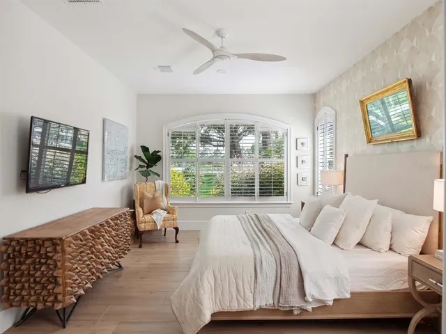 a bedroom with a bed and a large window