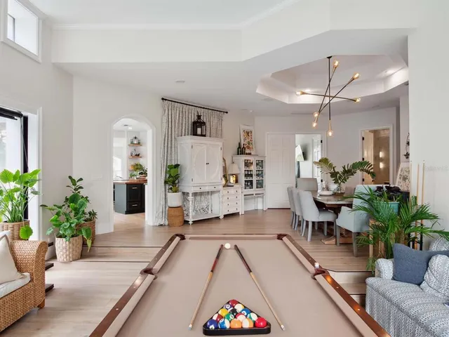 a living room with furniture potted plant and kitchen view