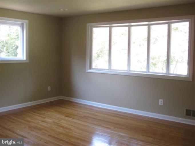 408 Hannes Street Silver Spring, MD 20901 - Photo 5 of 10 an empty room with wooden floor and windows
