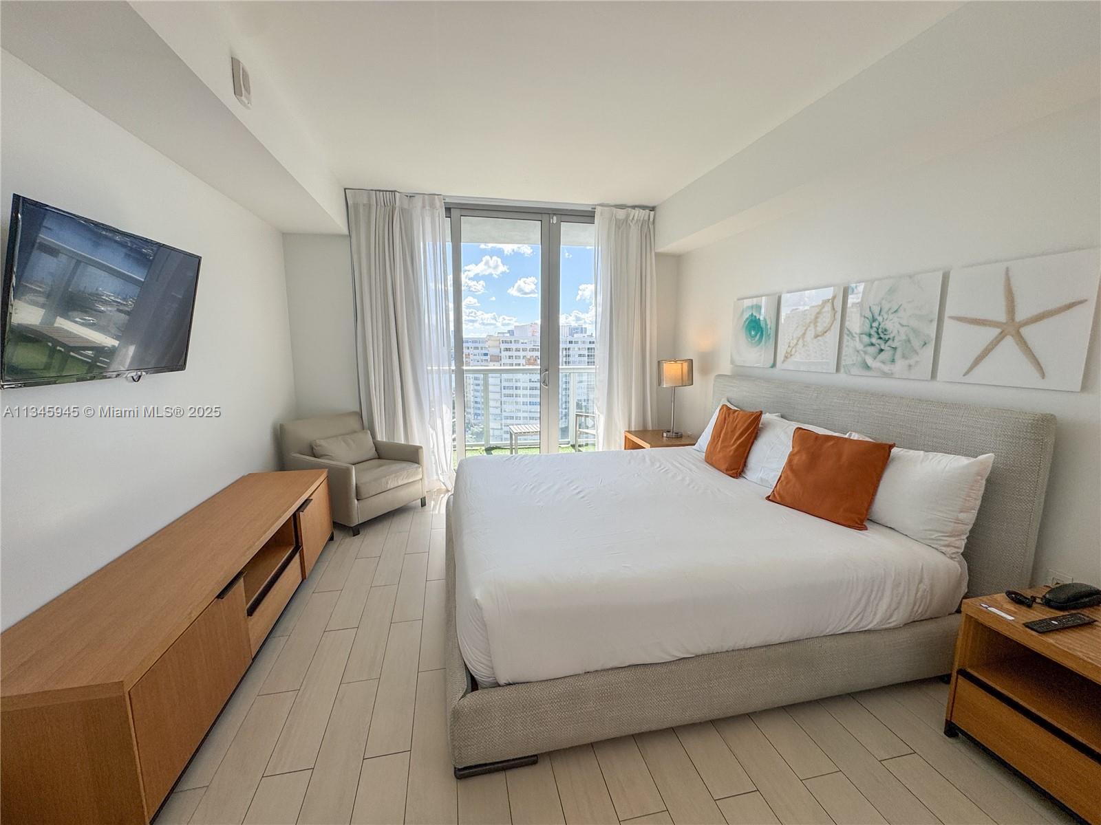 2602 East Hallandale Beach Boulevard, Unit R1409 Hallandale Beach, FL 33009 - Photo 11 of 32 a bedroom with a bed and a couch