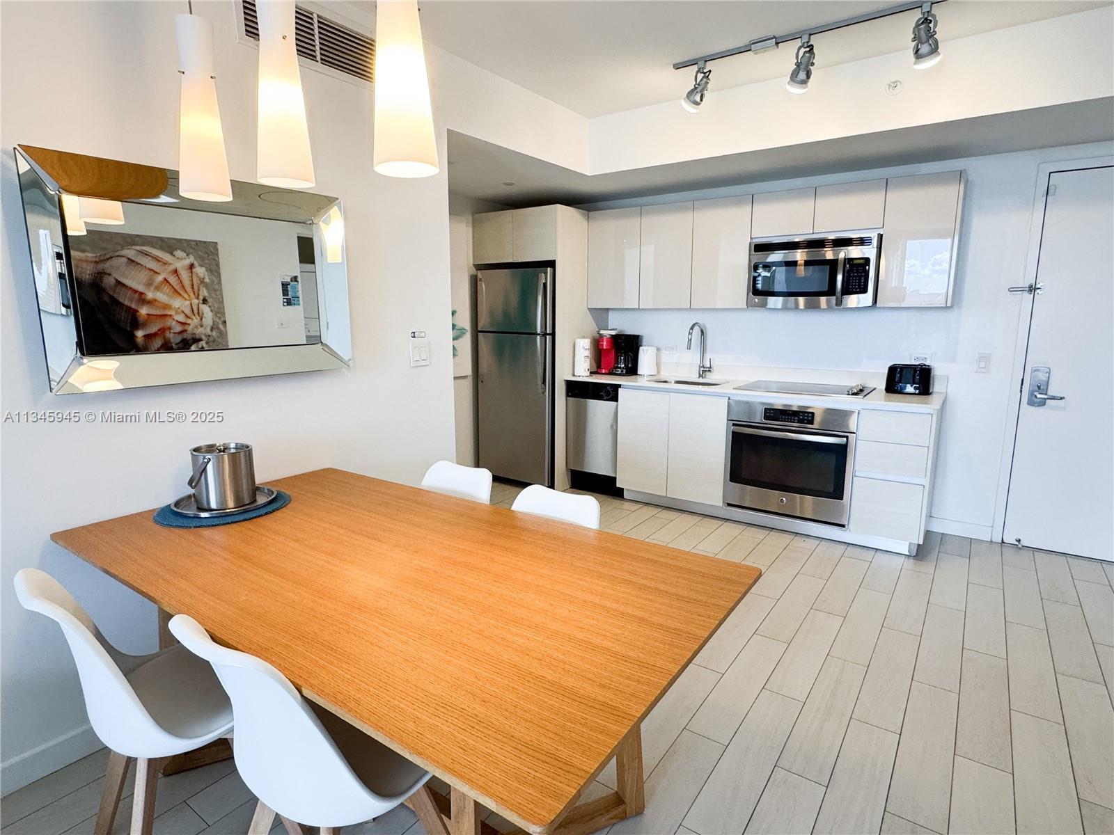 2602 East Hallandale Beach Boulevard, Unit R1409 Hallandale Beach, FL 33009 - Photo 4 of 32 a kitchen with stainless steel appliances granite countertop a sink dishwasher and cabinets with wooden floor