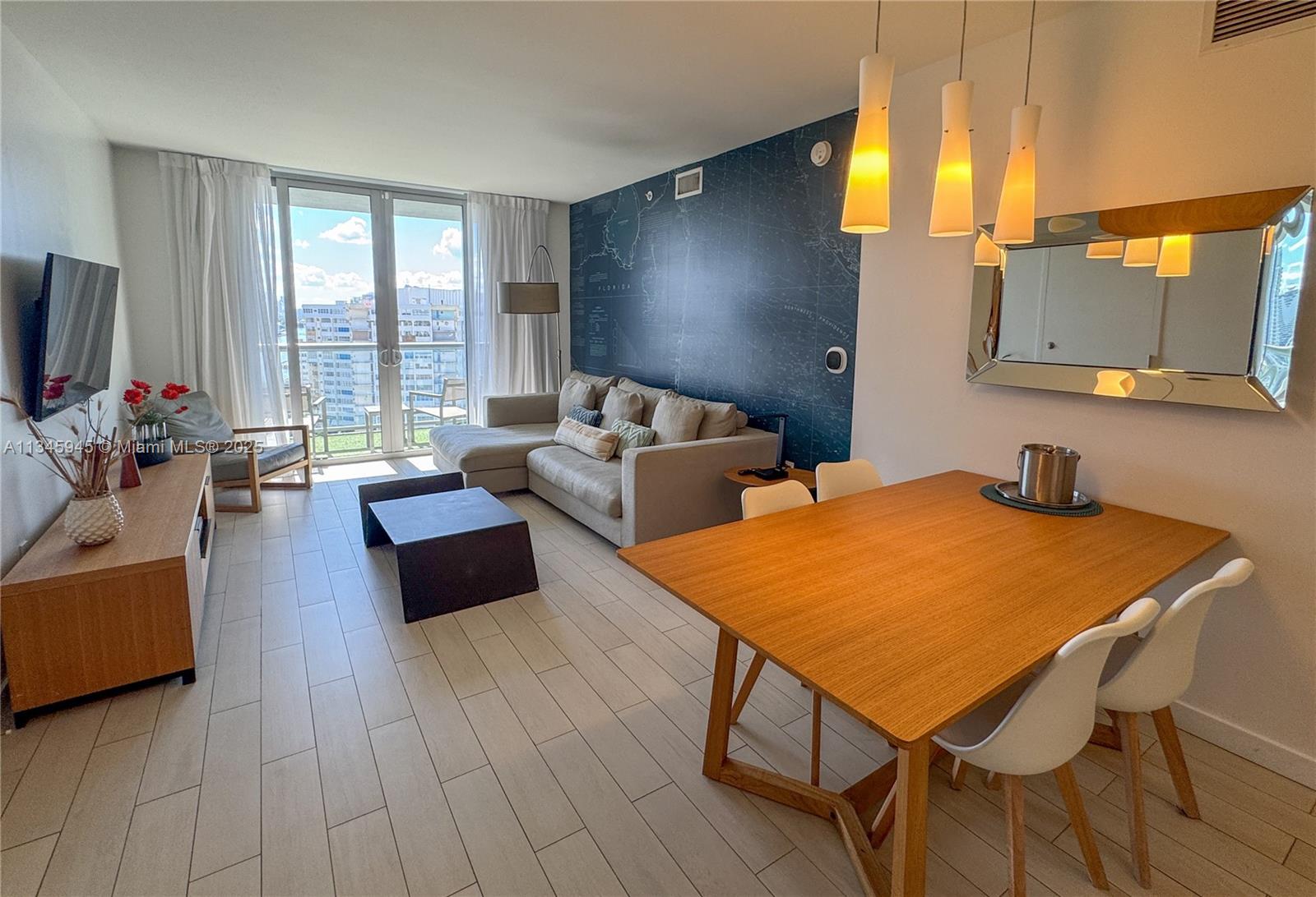 2602 East Hallandale Beach Boulevard, Unit R1409 Hallandale Beach, FL 33009 - Photo 5 of 32 a living room with furniture and a flat screen tv
