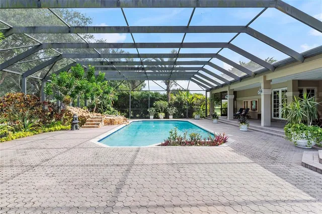 a view of a patio with table and chairs potted plants and large tree