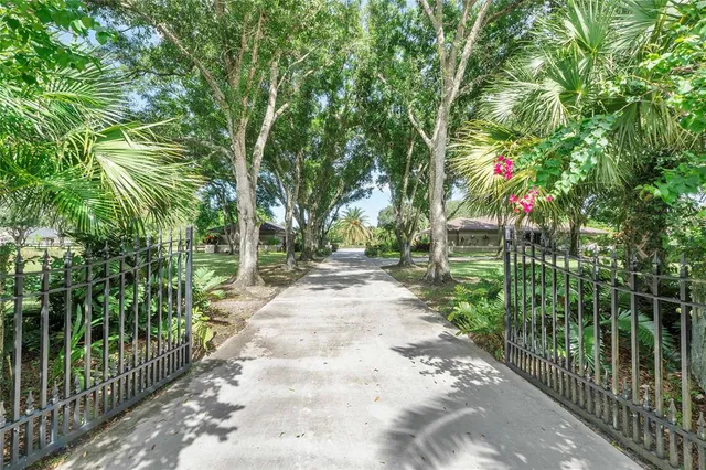 a front view of a house with a yard and potted plants