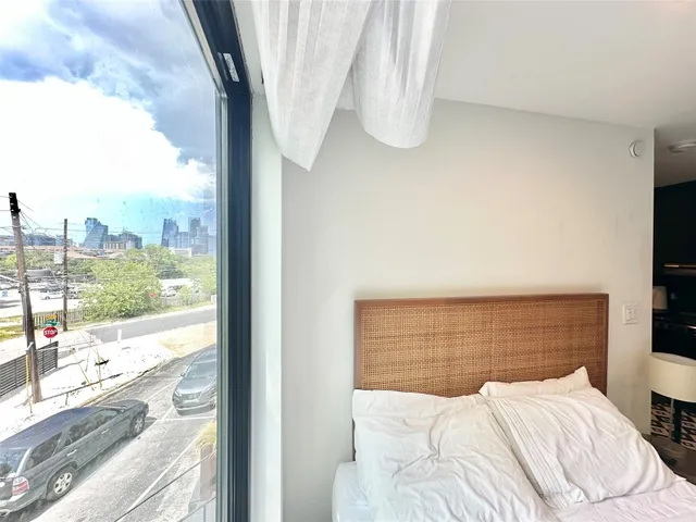 a bedroom with a large window and a bed