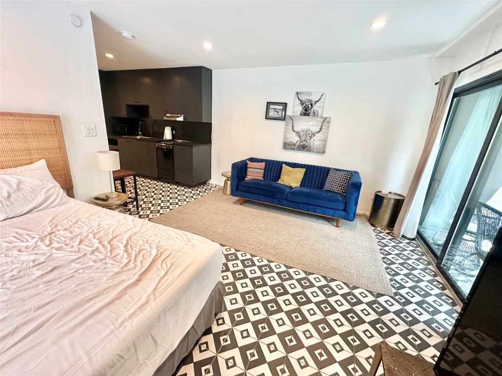 201 Academy Drive, Unit 201 Austin, TX 78704 - Photo 9 of 15 a bedroom with a bed and wooden floor