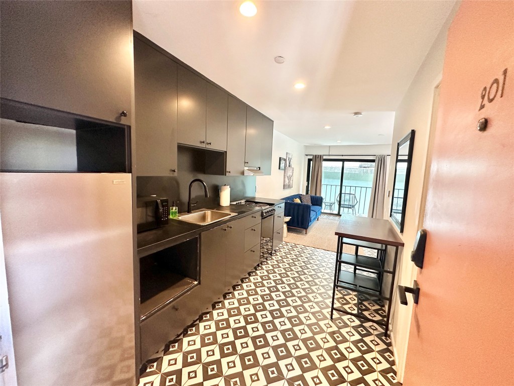 201 Academy Drive, Unit 201 Austin, TX 78704 - Photo 14 of 15 a kitchen with granite countertop a refrigerator and a stove top oven
