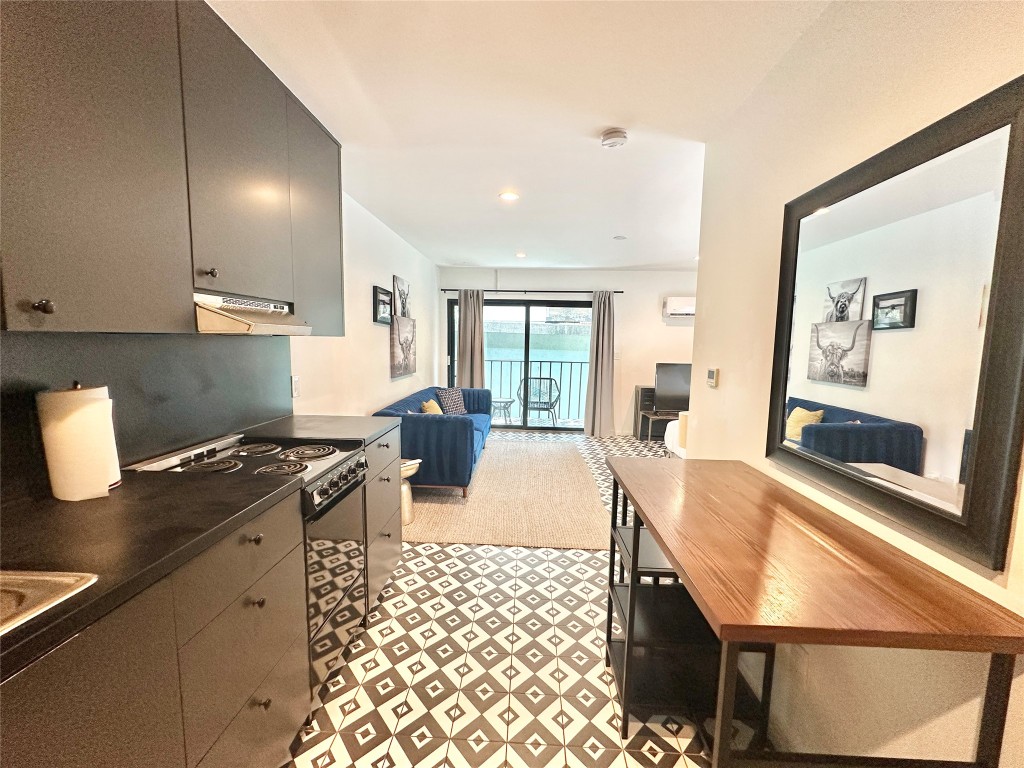 201 Academy Drive, Unit 201 Austin, TX 78704 - Photo 15 of 15 a kitchen with stainless steel appliances granite countertop a stove a sink and a microwave