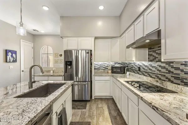 a kitchen with granite countertop a sink stainless steel appliances and cabinets