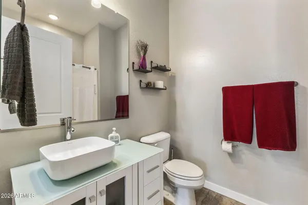 a bathroom with a sink vanity mirror and toilet