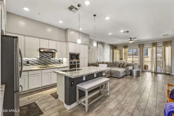 a kitchen with kitchen island granite countertop lots of counter top space and refrigerator