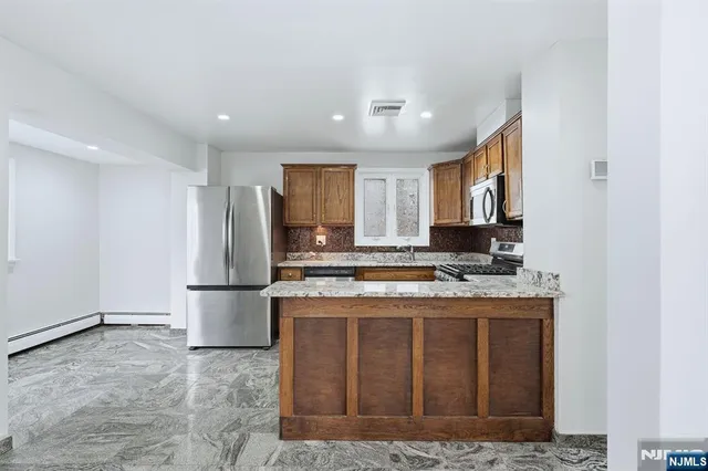 a kitchen with a refrigerator sink and cabinets