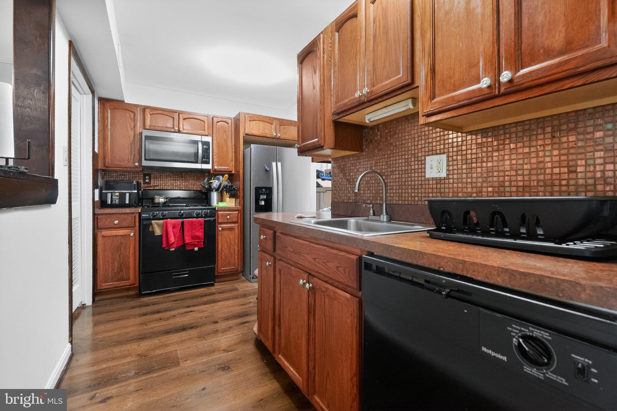 8587 Seasons Way, Unit 6B Lanham, MD 20706 - Photo 15 of 17 a kitchen with stainless steel appliances granite countertop a stove refrigerator and a microwave