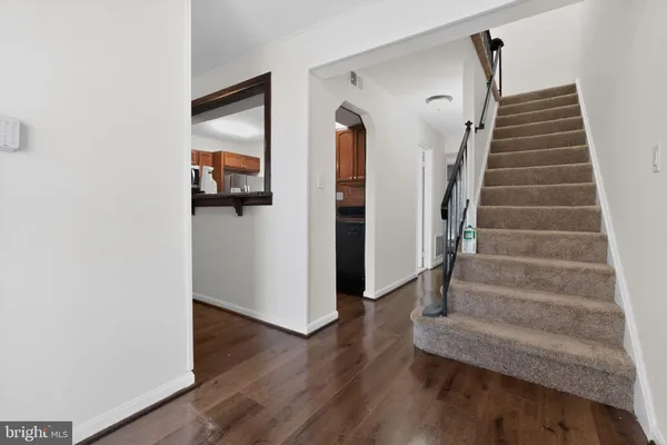 a view of a hallway with wooden floor and entryway