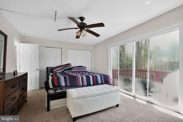 a living room with furniture a ceiling fan and a window