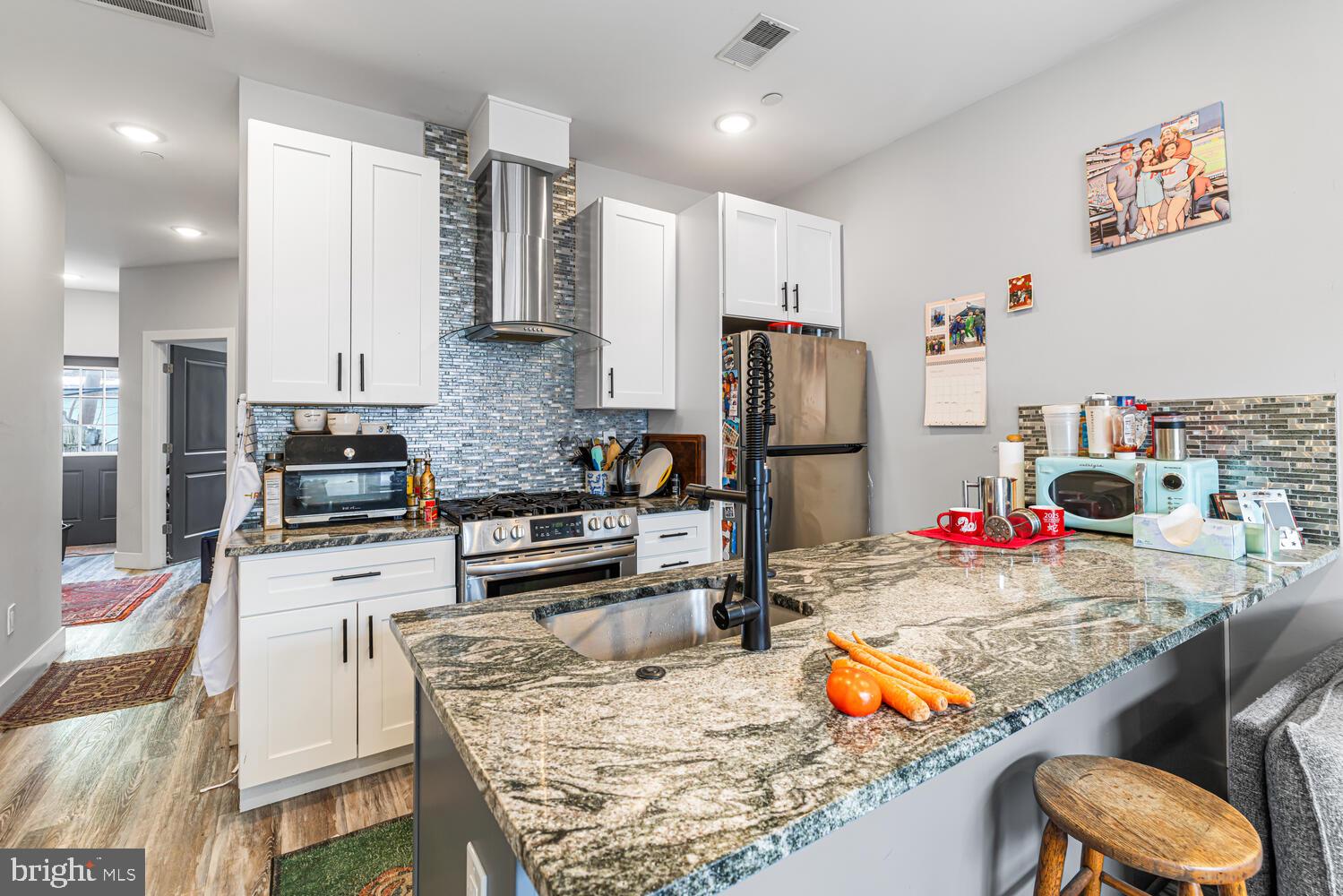 1214 South 20th Street Philadelphia, PA 19146 - Photo 21 of 34 a kitchen with stainless steel appliances kitchen island granite countertop a refrigerator and stove