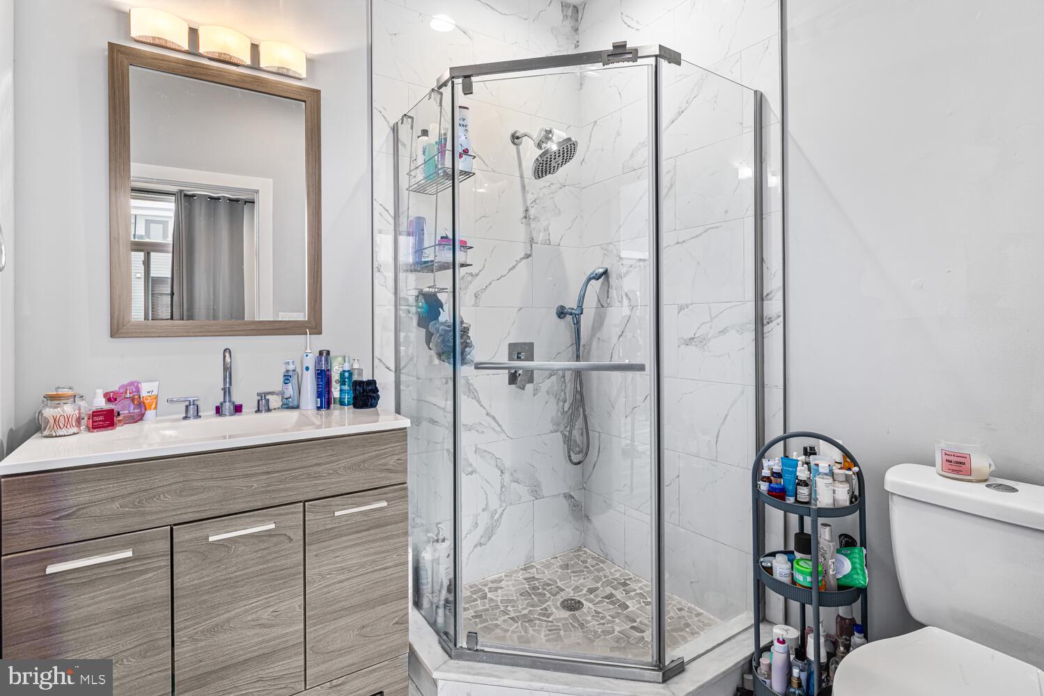 1214 South 20th Street Philadelphia, PA 19146 - Photo 31 of 34 a bathroom with a shower sink vanity mirror and toilet