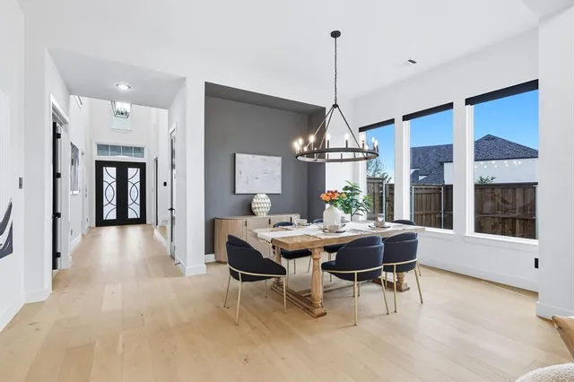 a view of a dining room and livingroom with furniture wooden floor a chandelier
