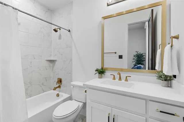 a bathroom with a sink a toilet a mirror a bathtub and shower