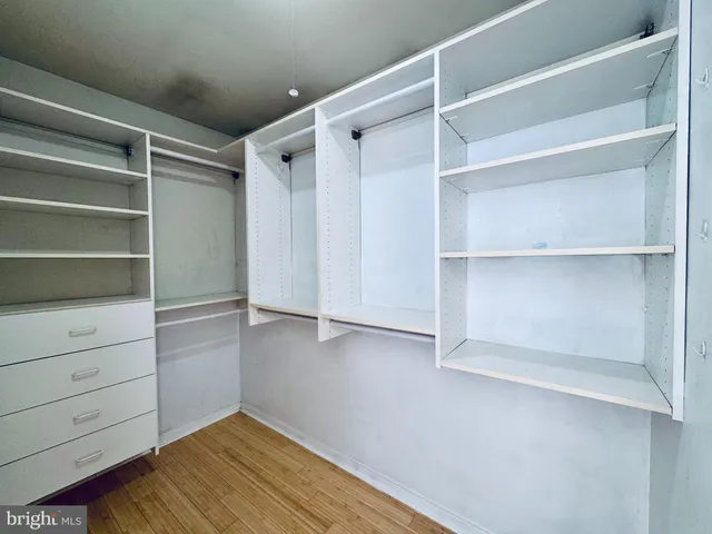 a view of walk in closet with empty racks