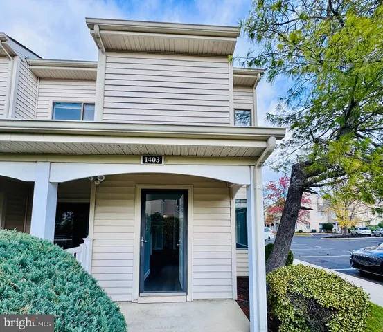 a front view of a house with a tree