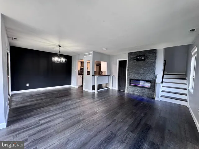 a view of a living room with wooden floor and stairs