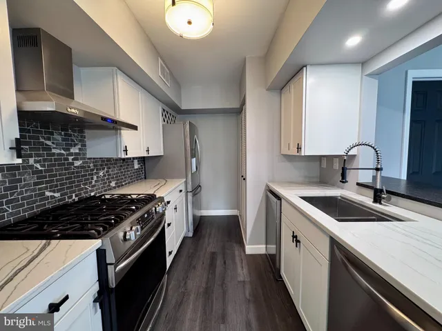a kitchen with a sink stove top oven and cabinets