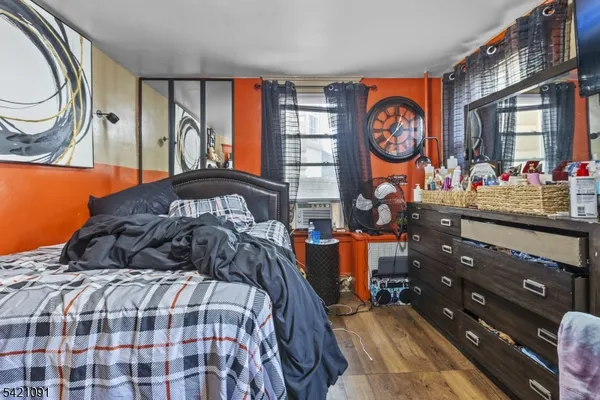 a bedroom with a bed a large window and dresser