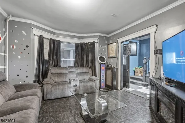 a living room with furniture a flat screen tv and a window