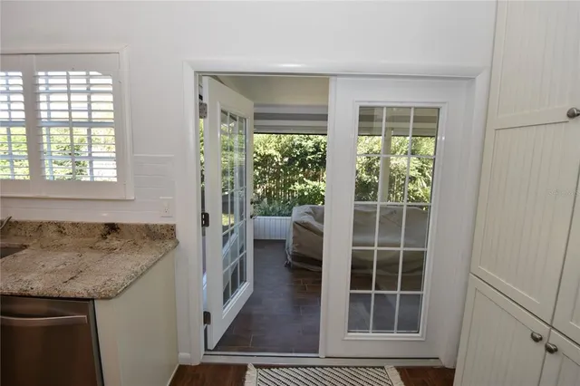 a living room with patio furniture and a floor to ceiling window